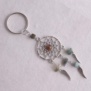 Detalle de llavero atrapasueños con alas plateadas, piedras naturales y plumas de metal