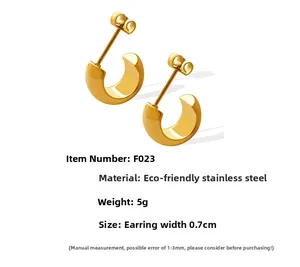 Détail macro de boucles d'oreilles C en acier doré 18 carats avec une largeur de 7 mm