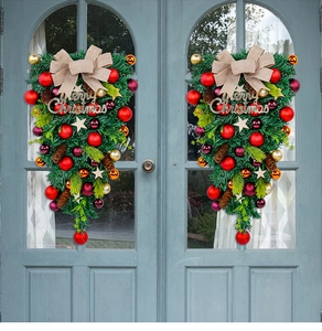 Christmas teardrop swag with red ornaments, pine cones, and Merry Christmas sign on door