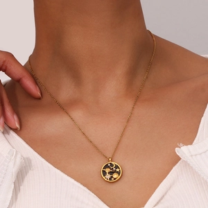 Detail of 18K gold stainless steel necklace with celestial star moon pendant on model
