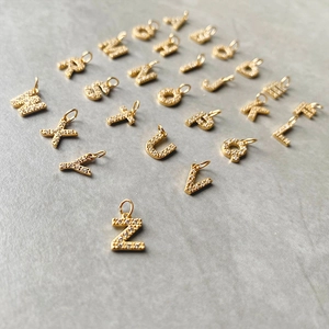Detailed view of sparkling gold-plated letter pendants with micro-inlaid cubic zirconia