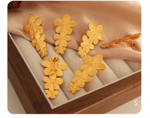 Detail of 18K gold plated stainless steel flower earrings with brushed texture finish