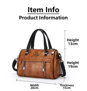 Close-up of brown vintage leather handbag showing grain texture and metal logo detail
