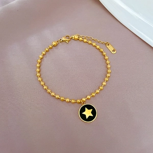 Dettaglio macro del bracciale a sfere in acciaio inossidabile dorato con stella