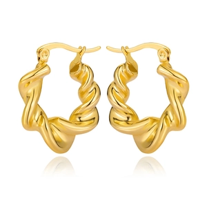 Detail showing the polished golden twisted hoop earrings with elegant metal texture
