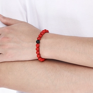 Close-up of red turquoise textured beads and black accent bead on a stretch bracelet