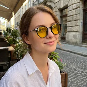 Retro round metal sunglasses with yellow lenses and black frame shown on model