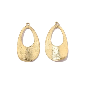 Macro detail of gold teardrop charms with unique fingerprint texture and top hanging holes