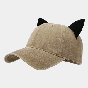 Detail view of khaki baseball cap featuring black cat ears and corduroy texture