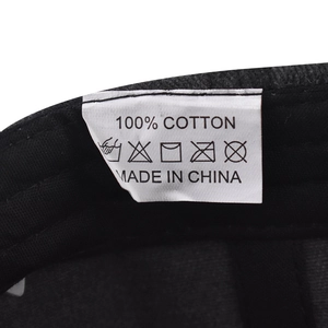 Détail de l'étiquette d'entretien d'une casquette en coton avec symboles de lavage
