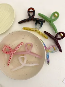 Detail of 13cm hanger hair claws in various colors arranged on a decorative ceramic bowl