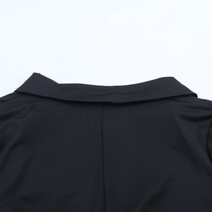 Detail of V-neck stitching and smooth black fabric texture on the jumpsuit