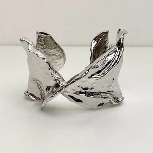Macro shot of silver crinkle texture and fluid irregular shape on open spring bracelet