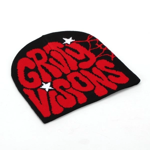 Détail du bonnet en maille avec motif toile d'araignée rouge et lettrage graphique brodé