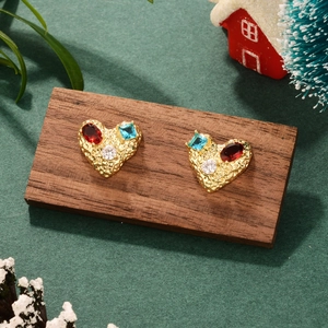 Vintage gold heart earrings with colorful zircon gems on a festive holiday backdrop