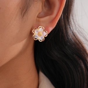 Close-up of a delicate five-petal flower earring with pearlescent purple finish