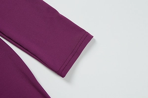 Detail of double-needle stitching on the cuffs of a deep purple slim fit dress