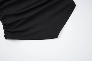 Détail rapproché d'un tissu en maille côtelée noire avec coutures et texture élastique