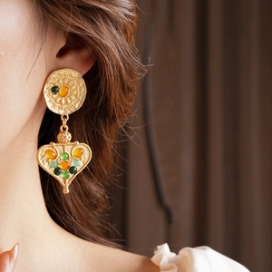 Detail of vintage heart drop earrings with colorful resin stones on a model