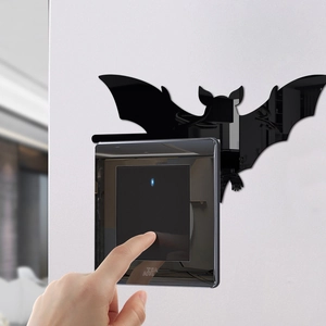 Macro detail of a 3D black acrylic mirror bat sticker applied above a modern light switch