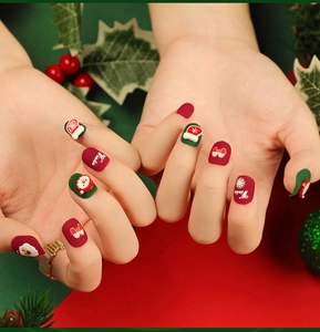 Detail of matte Christmas press-on nails with Santa Claus and snowflake designs