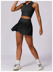 Dynamic view of black pleated tennis skirt and sleeveless polo vest on a fitness model