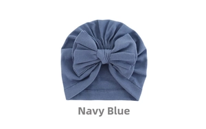 Detail of baby turban hat in navy blue featuring a large decorative bow and soft ribbed cotton