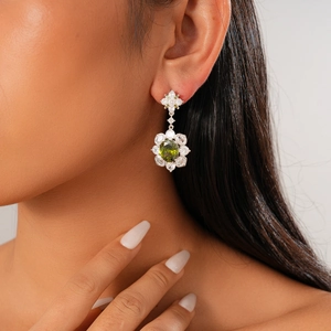 Elegant olive green oval gemstone flower earrings with silver needle in a side-view portrait