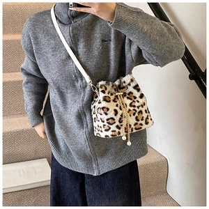 Detail of plush leopard print bucket bag with gold chain and pearl drawstring charms