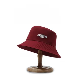 Détail d'un chapeau bob bordeaux avec broderie blanche et coutures renforcées