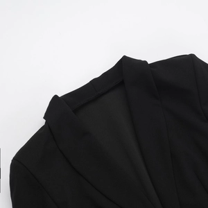 Gros plan détaillé du revers élégant et de la texture du tissu noir de la robe veste