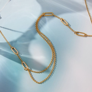 Dettaglio macro della collana a doppio strato placcata in oro con maglie ovali in zircone