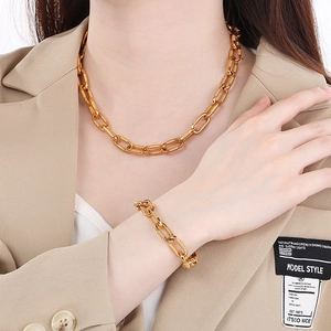Unisex gold stainless steel cable chain necklace and bracelet set shown on a model