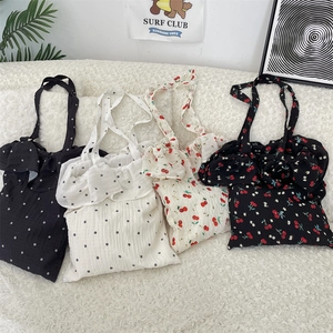 Flat lay of four tote bags with floral and cherry patterns featuring ruffled edge details
