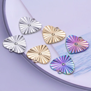 Macro view of heart-shaped stainless steel pendants in gold, silver and rainbow colors