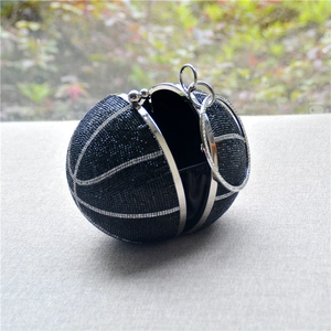 Close-up of black rhinestone basketball evening bag with silver ring handles and metal frame