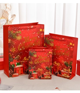 Close-up of three red Christmas paper gift bags with golden Merry Christmas embossing