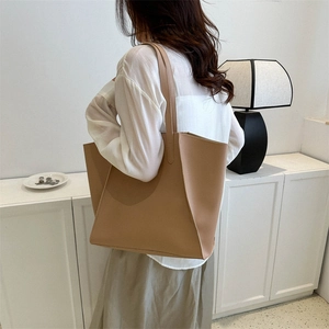 Minimalist khaki large capacity tote bag in high-quality PU leather worn over the shoulder