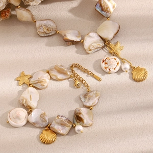 Détail d'un ensemble de pendentifs étoile de mer et coquillage dorés 18 carats avec perles