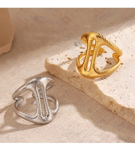 Macro detail of gold and silver chunky rings with spiral texture on stone base