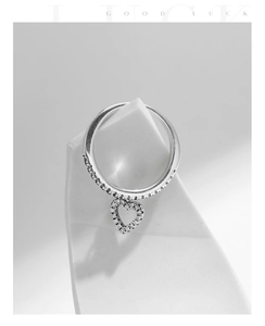 Macro shot of S925 silver heart charm ring with sparkling pavé cubic zirconia