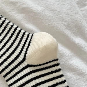 Detailed close-up of thick black and white striped wool sock with reinforced white heel