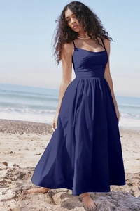Detail of a dark blue backless maxi dress featuring a high waist design on a scenic beach