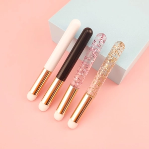Detail of four mini round head lip brushes with glitter and solid color handles