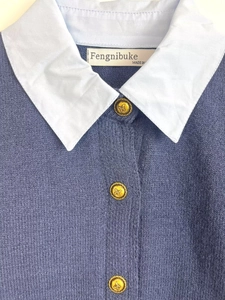 Détail du pull en maille bleu avec un col polo blanc et des boutons dorés décoratifs