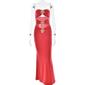 Detalle de vestido rojo con hombros descubiertos y tres hebillas doradas decorativas