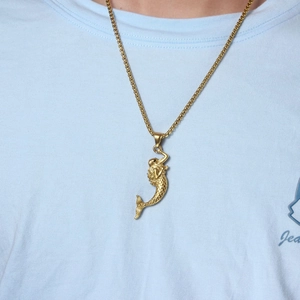 Close-up of golden mermaid pendant necklace featuring a detailed scale texture and box chain