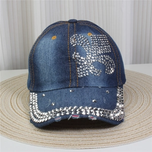 Détail d'une casquette en denim avec motif floral en strass et finitions en rivets