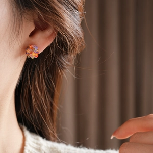 Close-up of model wearing colorful beaded flower stud earrings with vibrant crystal petals