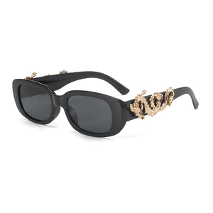 Close-up of golden dragon metal carving on black oval punk sunglasses temples
